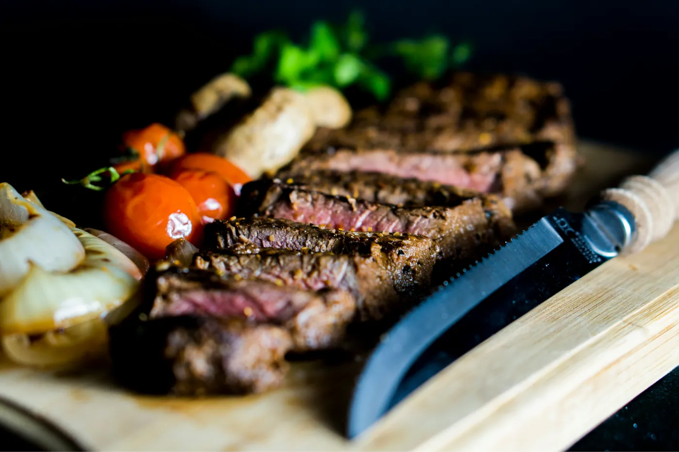 Illustrative stock photograph of grilled steak with vegetables and a steak knife